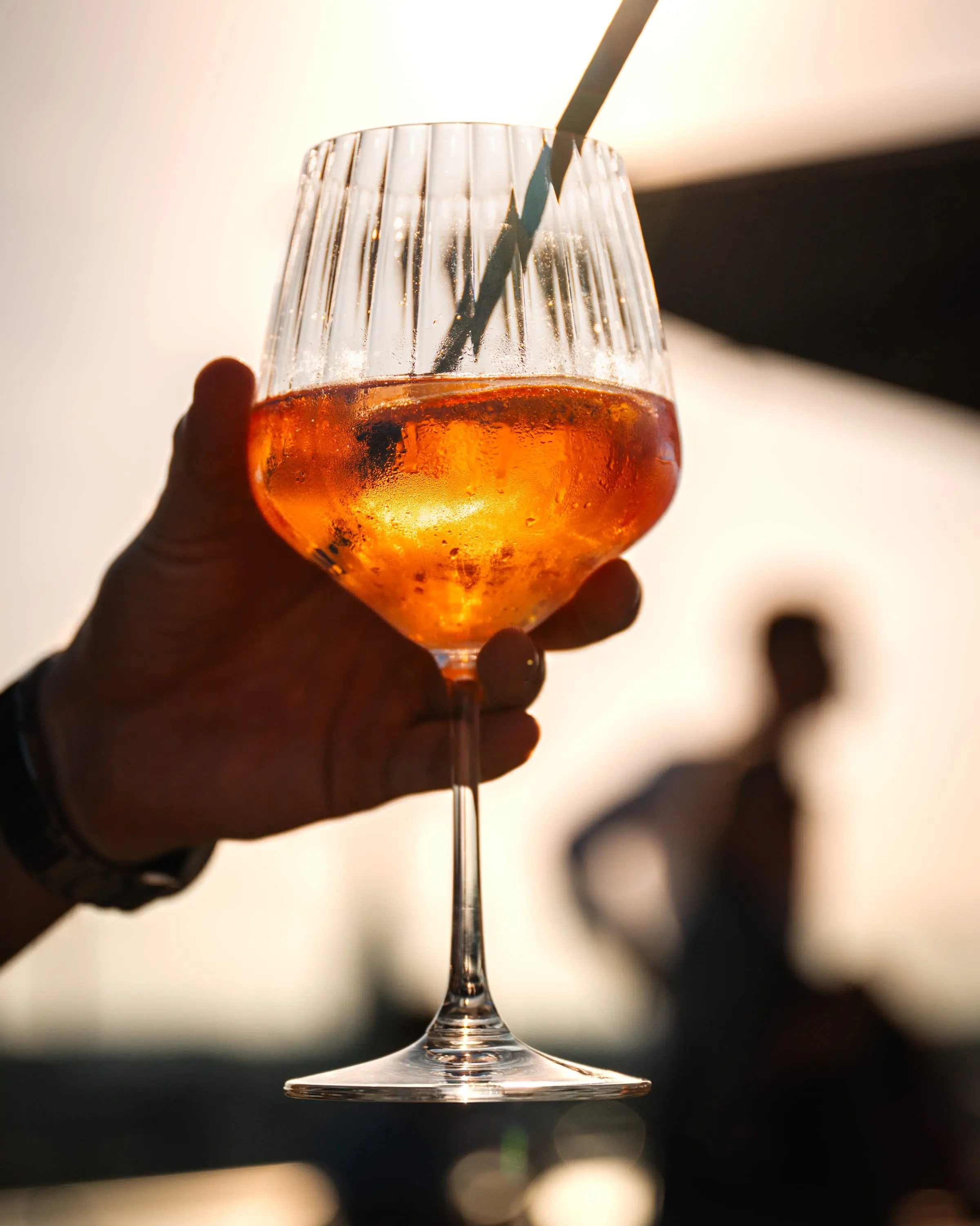 Aperol Spritz im Gegenlicht der Abendsonne, Silhouette im Hintergrund