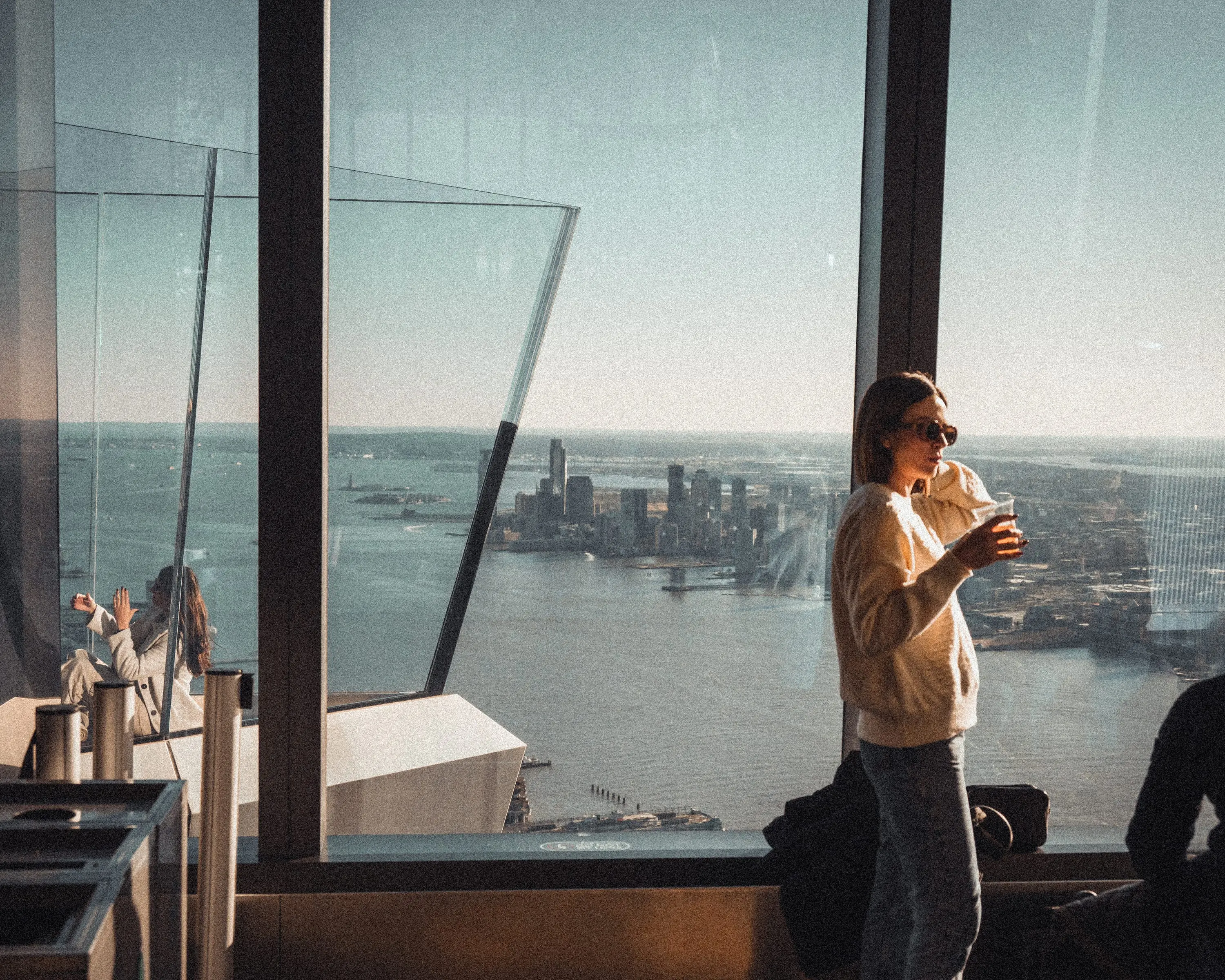 Person mit Kaffee an der Aussichtsplattform hoch über New York